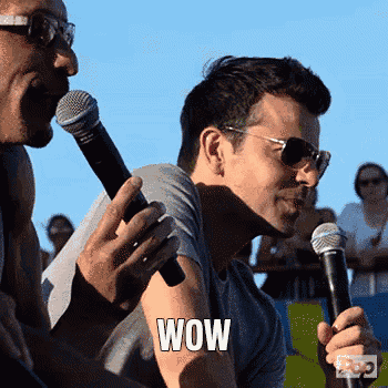 a man holding a microphone with the word wow written on his arm