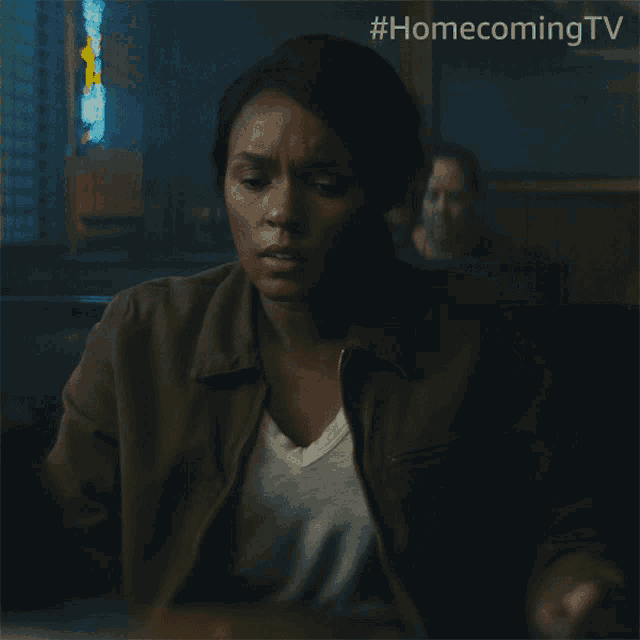 a woman sitting in a diner with #homecomingtv written on the bottom of the image