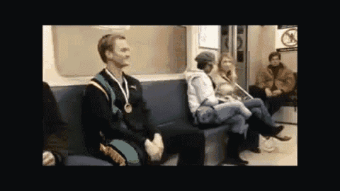 a man wearing a medal is sitting on a subway train