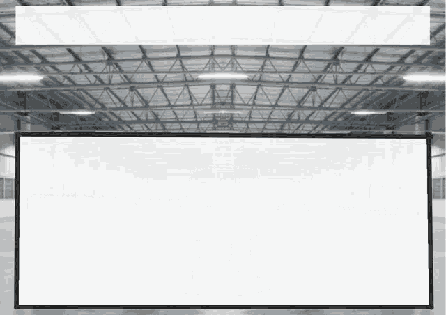 a large white sign is hanging from the ceiling of a large building