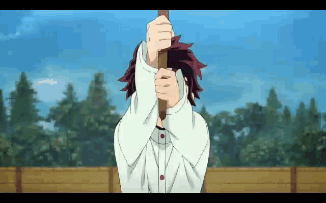 a man is holding a stick in front of his face .