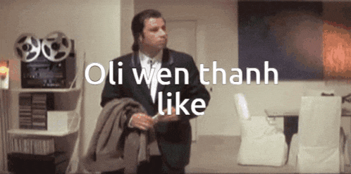 a man in a suit is standing in a room with the words oli wen thanh like written above him