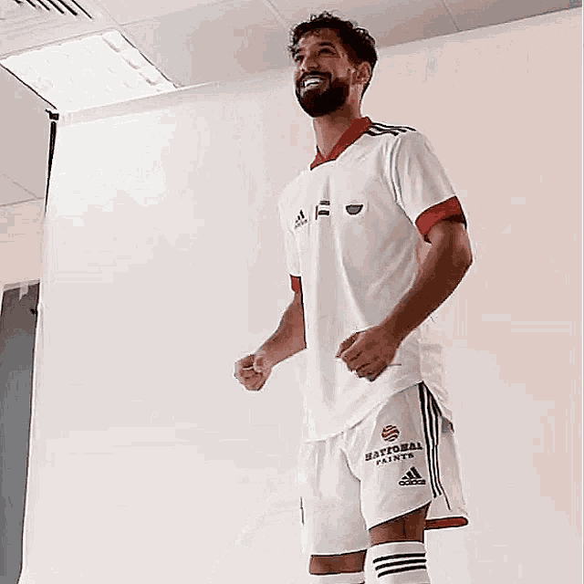 a man with a beard is wearing a white adidas jersey