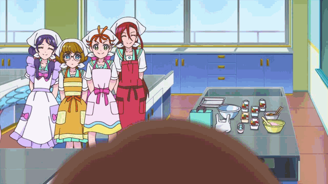 a group of girls in aprons are standing in a kitchen smiling