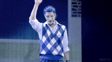 a man wearing a blue and white checkered vest is giving a high five