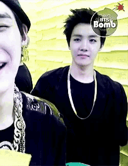 two young men are standing next to each other with a sticker that says bts bomb
