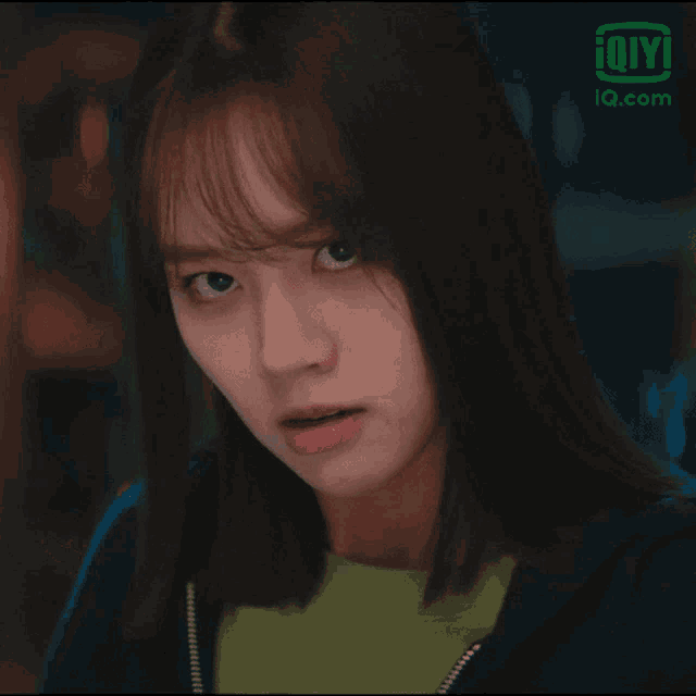 a close up of a woman 's face with an ioiyi logo in the background
