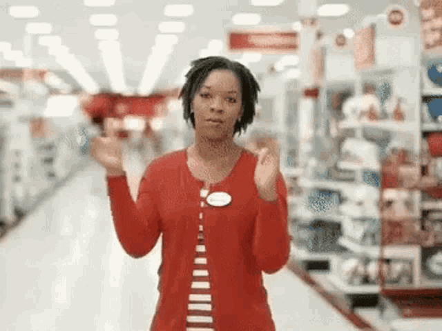 a woman in a red sweater is standing in a store