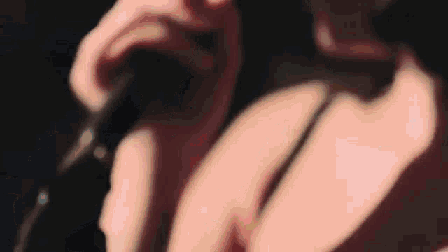a close up of a person holding a microphone in a dark room .