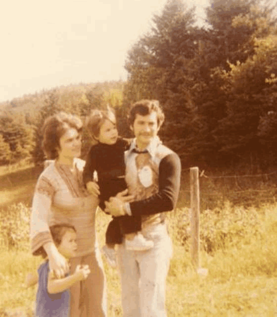 a family poses for a picture in a field