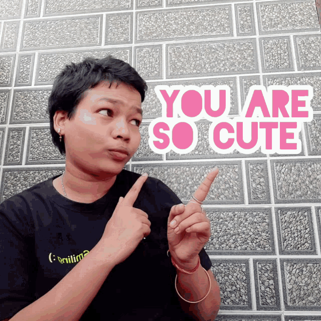 a woman is pointing to a sign that says you are so cute