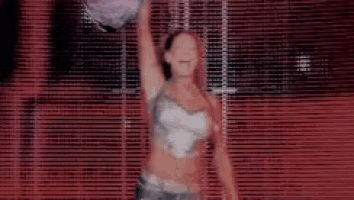 a woman is holding a balloon in her hand while standing in front of a red wall .