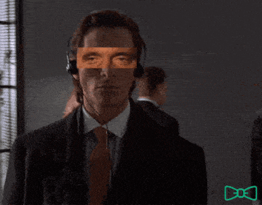 a man in a suit and tie has a mask on his face while wearing headphones