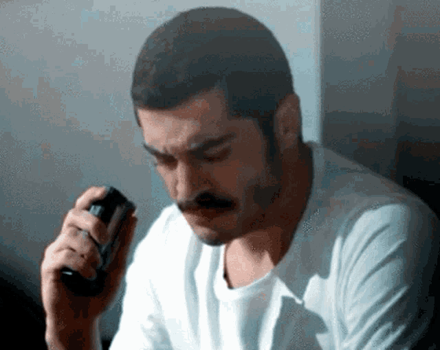 a man with a mustache is holding a glass in his right hand
