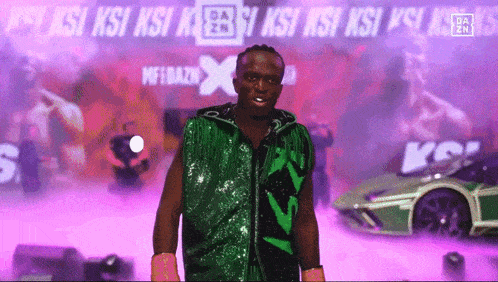 a man in a green vest stands in front of a sign that says ksi ksi ksi ksi ksi ksi ksi