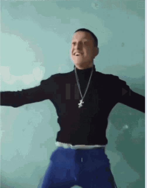 a man wearing a black shirt and blue pants is dancing
