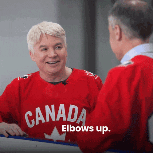 a man wearing a red canada elbows up shirt