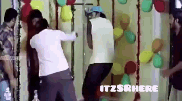a group of men are standing in front of a wall with balloons .