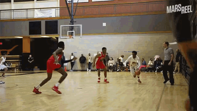 a basketball game is being played in a gym with a sign that says mars reel