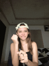 a woman wearing a white baseball cap is holding a pen in her hand