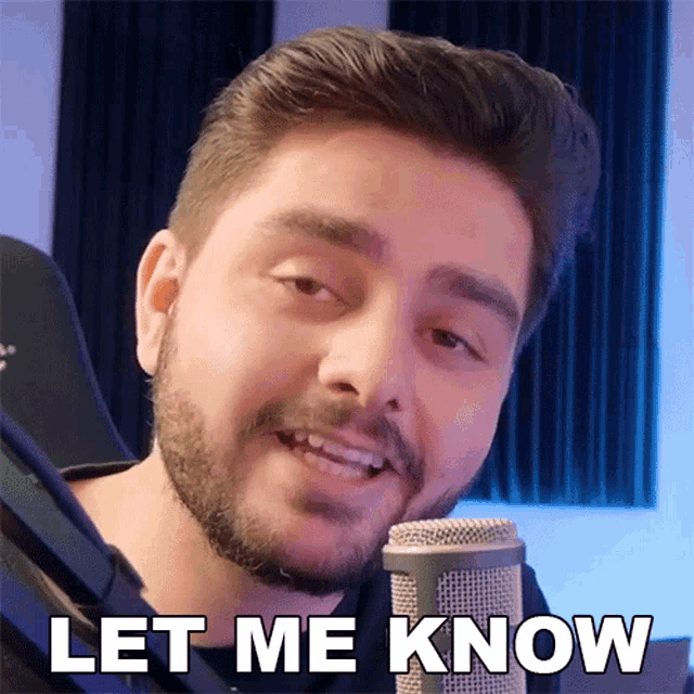 a man with a beard is talking into a microphone with the words let me know written below him