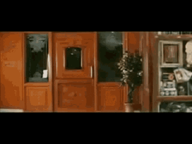 a wooden door with a plant in front of it and a sign that says ' hotel ' on it