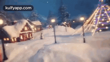 a snowy village with a christmas tree and houses covered in snow