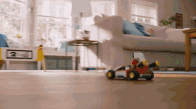a toy car is driving through a living room .
