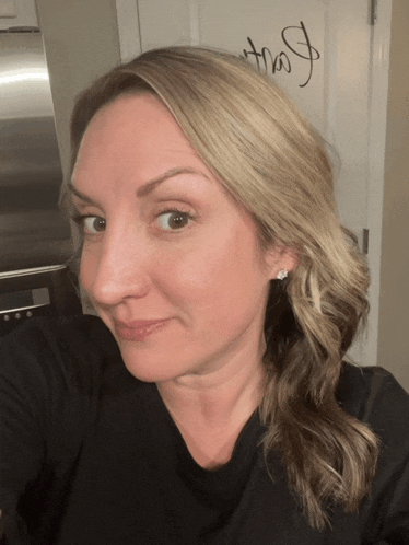 a woman takes a selfie in front of a door that says that