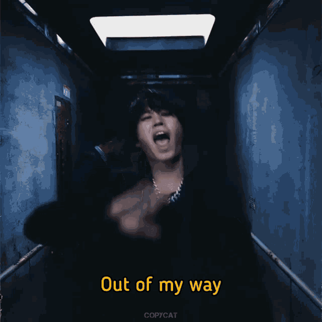 a man in a dark hallway with out of my way written on the bottom