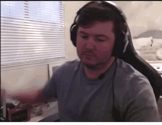 a man wearing headphones is sitting in a chair in front of a computer screen .