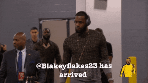 a man wearing headphones walks down a hallway with the words blakeyflakes23 has arrived below him