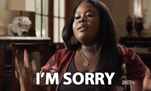 a woman says " i 'm sorry " in front of a window