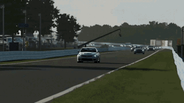 a silver car is driving on a race track