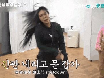 a woman with long hair is dancing in a room with chinese writing on the wall