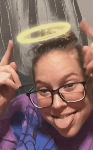 a woman wearing glasses and a halo on her head is sticking out her tongue .
