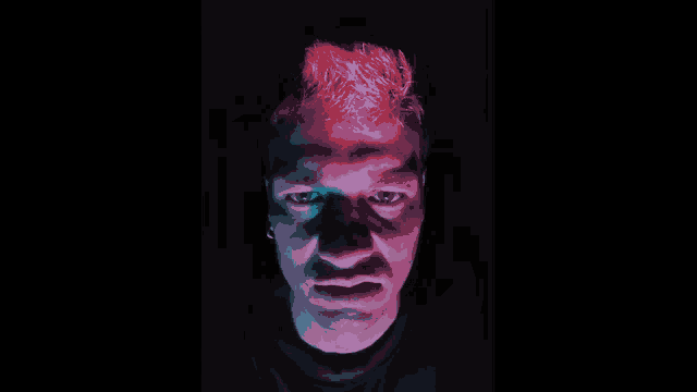 a close up of a man 's face in a dark room