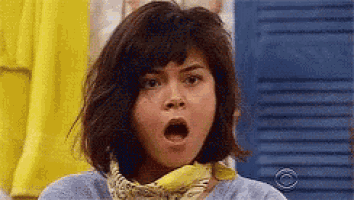 a woman with a bandana around her neck is making a surprised face with her mouth open .