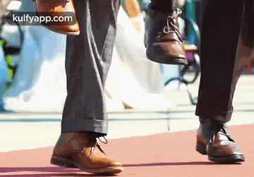 a close up of a person 's feet walking down a sidewalk .