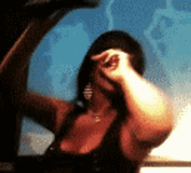a woman is dancing in front of a blue wall