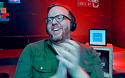 a man wearing headphones is clapping in front of a level up sign