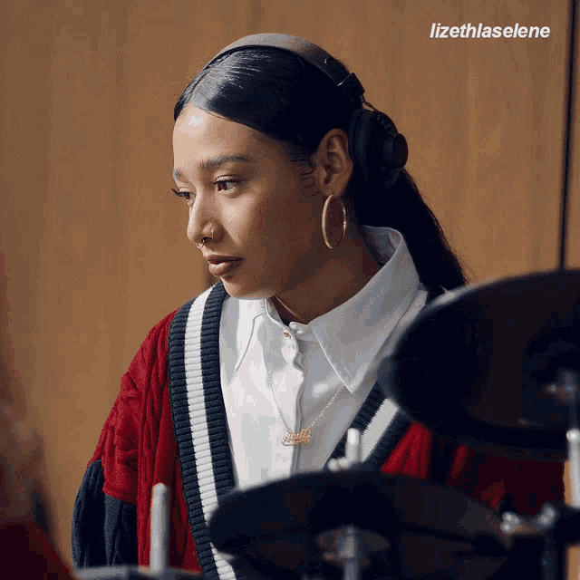 a woman wearing headphones and a necklace that says nike