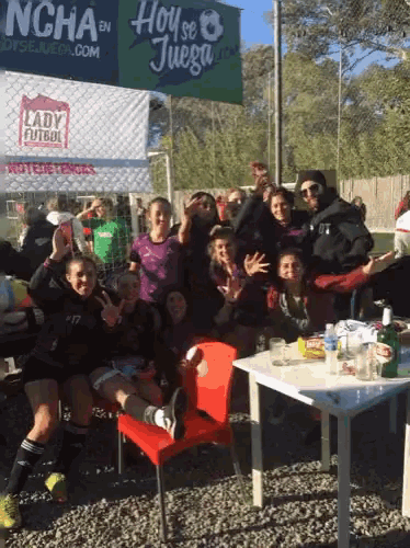 a group of people are posing for a photo in front of a sign that says hoy se juega