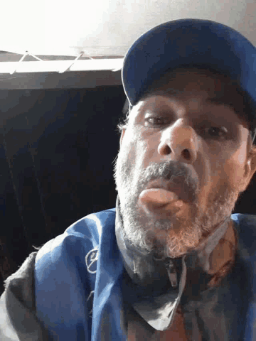 a man with a beard wears a blue hat and a blue jacket