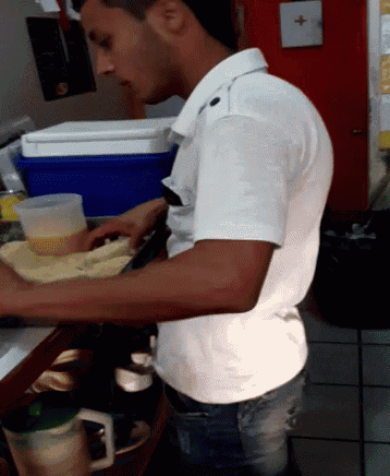 a man in a white shirt is standing at a counter