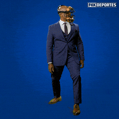 a man in a suit and tie is holding a baseball helmet in front of a blue background with fox deportes written on it