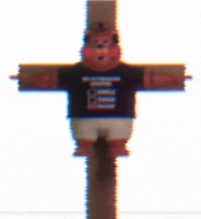 a teddy bear is sitting on a cross wearing a shirt that says `` i 'm not a jesus '' .