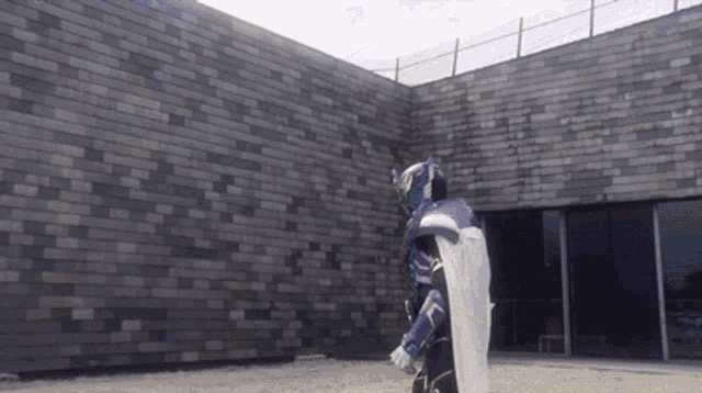 a person in a purple and white costume is standing in front of a brick wall