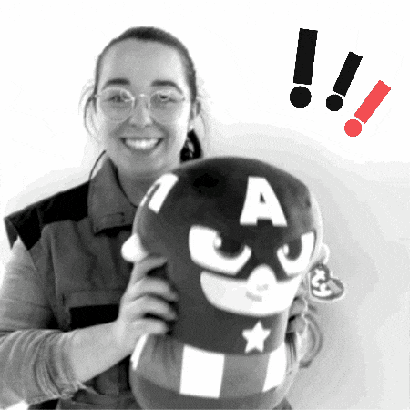 a black and white photo of a woman holding a stuffed captain america pillow