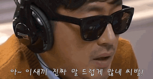 a man wearing sunglasses and headphones with korean writing on the bottom right